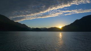 A sunset over mountains and water in Canada - Photo by Adrian McGrath